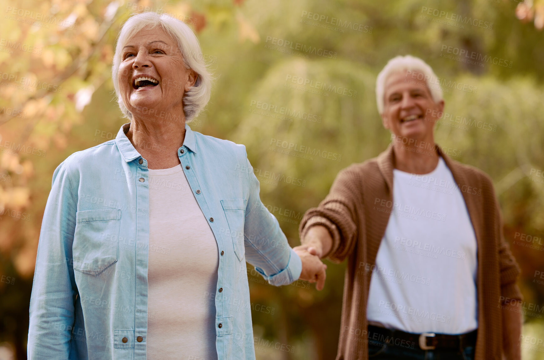 Buy stock photo Senior couple, holding hands and happy smile together in park, romance and love outdoor in park on date. Elderly man, woman and walking in forest, autumn and enjoy marriage relationship in nature