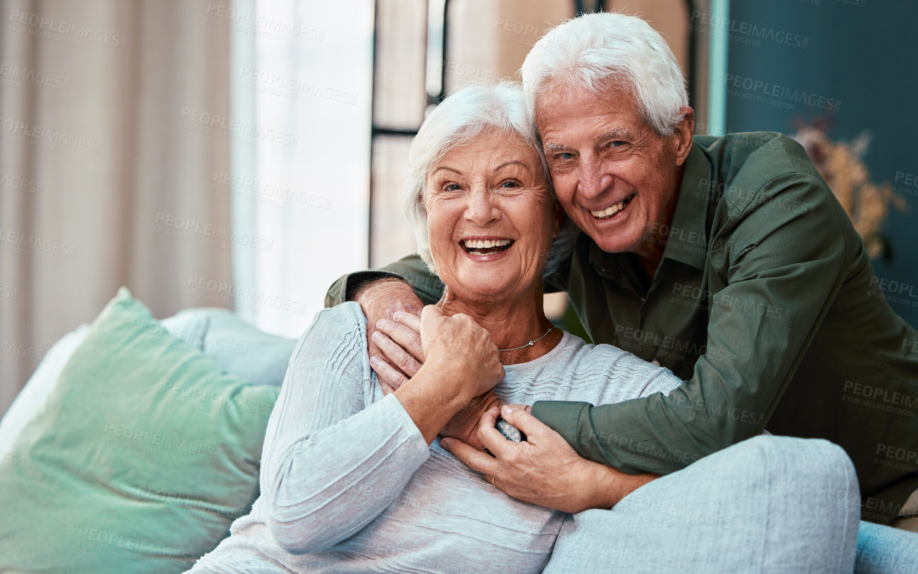 Buy stock photo Portrait, hug and senior couple in living room in home, smiling and bonding. Love, retirement and smile of happy elderly man and woman on sofa, embrace and enjoying quality time together in house.