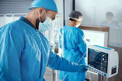 Buy stock photo Doctor, hospital and medical machine with monitor screen during surgery for dialysis, healthcare and analysis in a room with a face mask and scrubs. Surgeon man pressing button on cardiology device