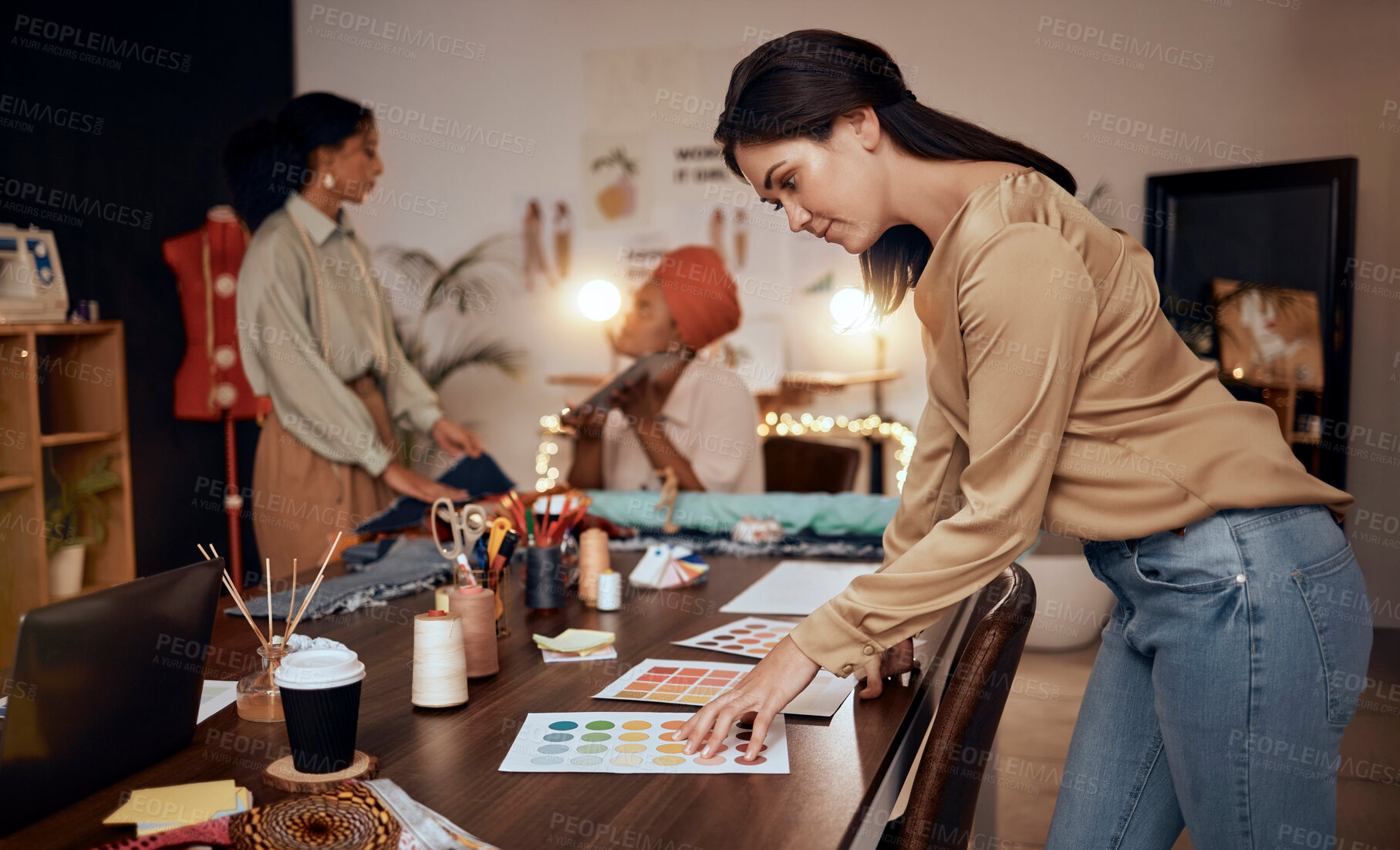 Buy stock photo Fashion, workshop and manufacturing women at night for small business, startup production or retail management of color choice. Textile industry, clothes supplier and people at desk in team planning