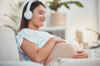 Buy stock photo Pregnant woman, music and holding belly or bump while relaxing and bonding with her baby at home. Babies, mother touching stomach and listen to audio on headset for bond in family home