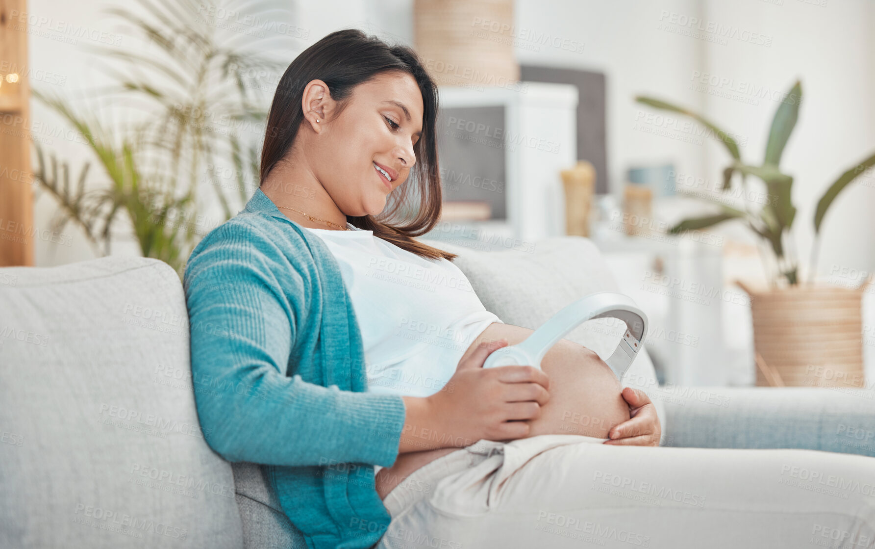 Buy stock photo Pregnant, woman and stomach with headphones for music for her unborn baby while relaxing at home. Belly, baby bump and pregnancy with a mother using a headset for audio or podcast streaming 