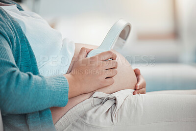 Buy stock photo Relax, pregnant woman and headphones on stomach, music playing for baby in living room. Pregnancy, earphones on belly and technology, woman on sofa streaming audio sound for child listening in utero.