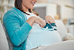 Pregnant woman, baby shoes and sofa with happiness, excited and planning for child future in home. Happy young mother, infant sneakers and stomach with smile, vision and playful on living room couch