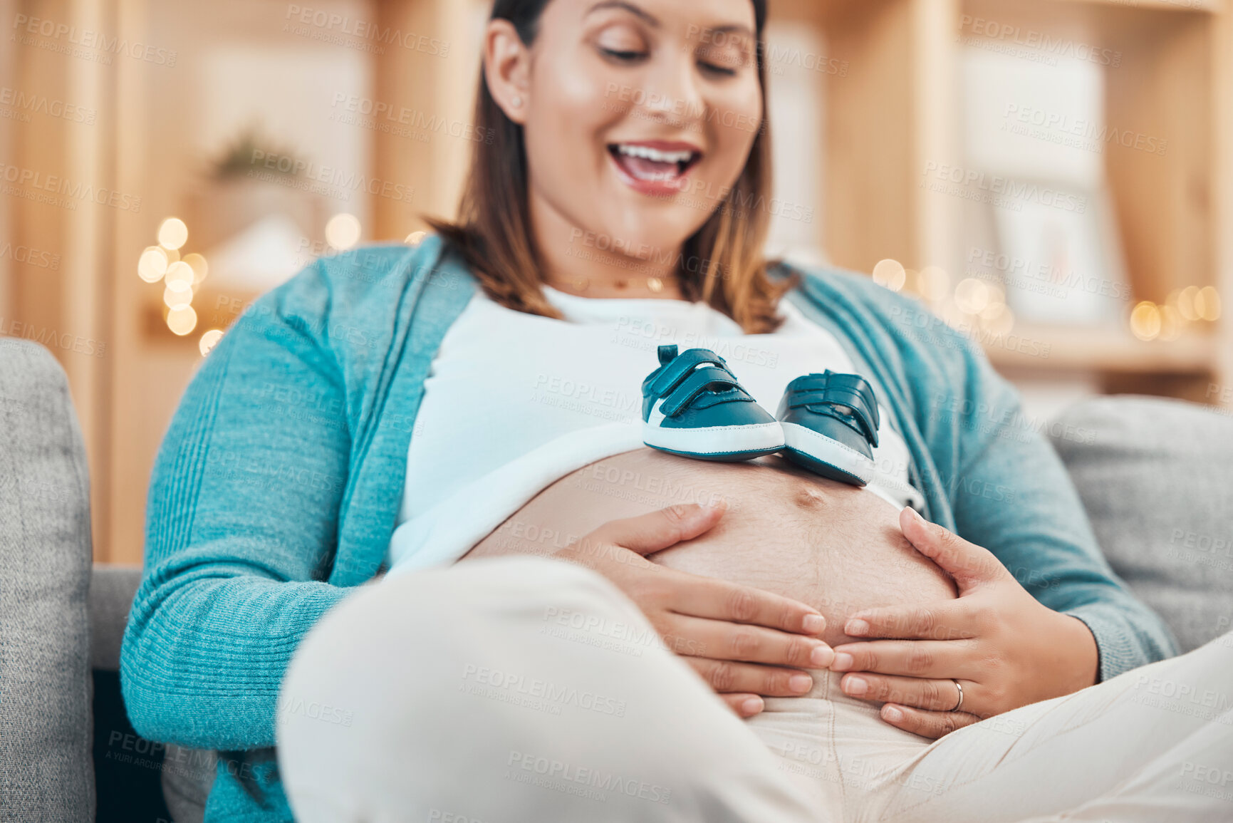 Buy stock photo Mother, pregnancy and pregnant stomach in hands, woman with shoes for baby, excited about childbirth and happy at family home. Happiness, mama and love, prenatal health and wellness with maternity.