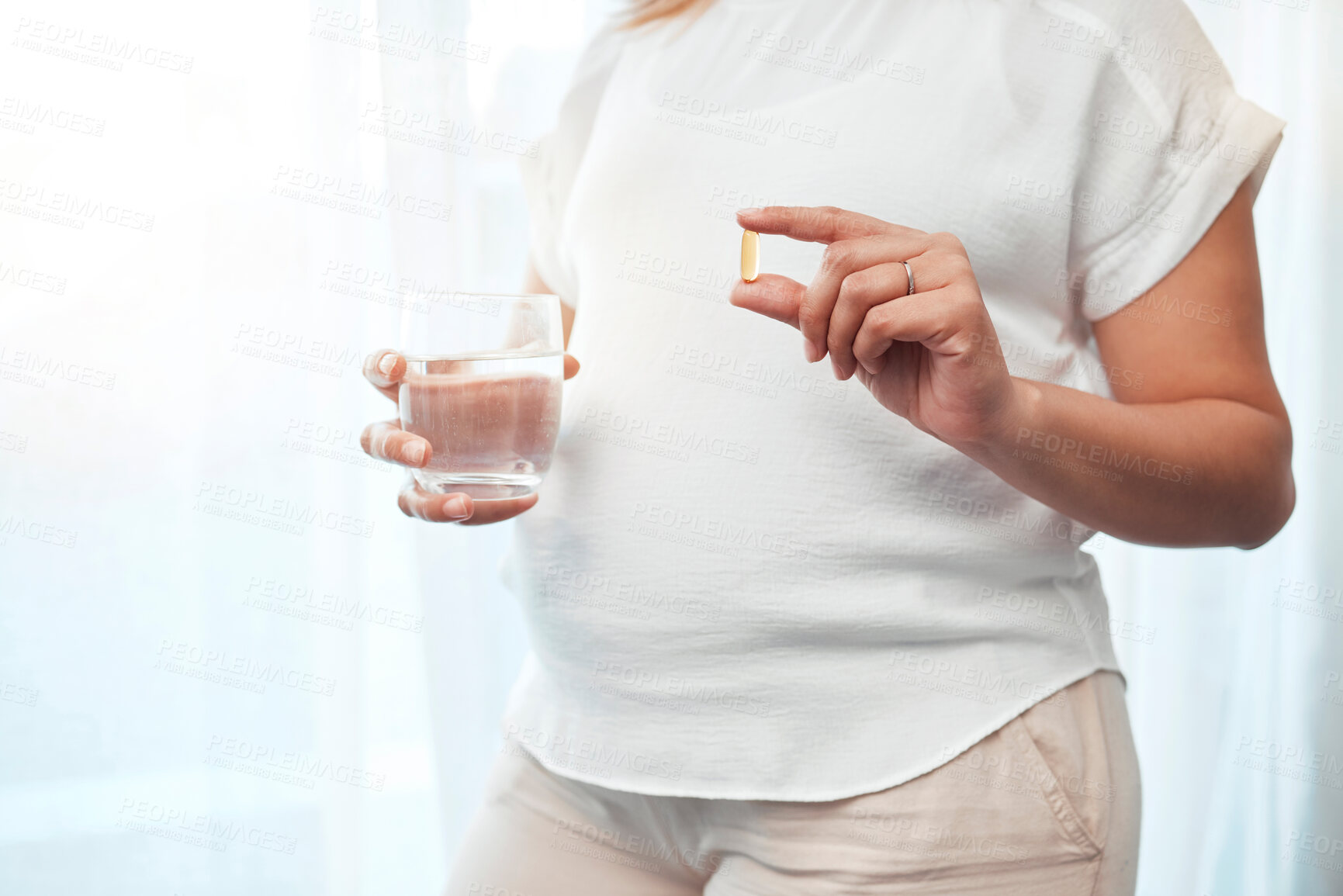 Buy stock photo Pregnancy, health and woman with pills and water for wellness, vitamins and medical care for baby. Healthcare, medicine and pregnant woman hands with glass taking medication, minerals and supplements