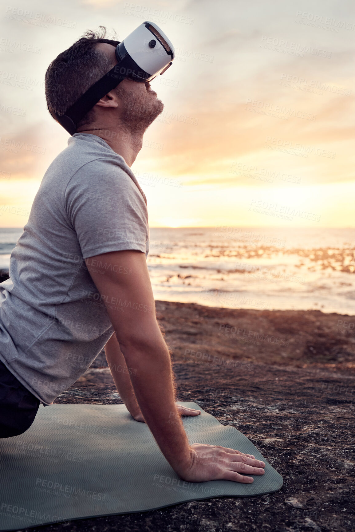 Buy stock photo VR, yoga and man stretch on the beach for fitness, flexibility and health and wellness at sunset. Metaverse, ai and futuristic male yogi with a headset and yoga mat for training and ocean pilates