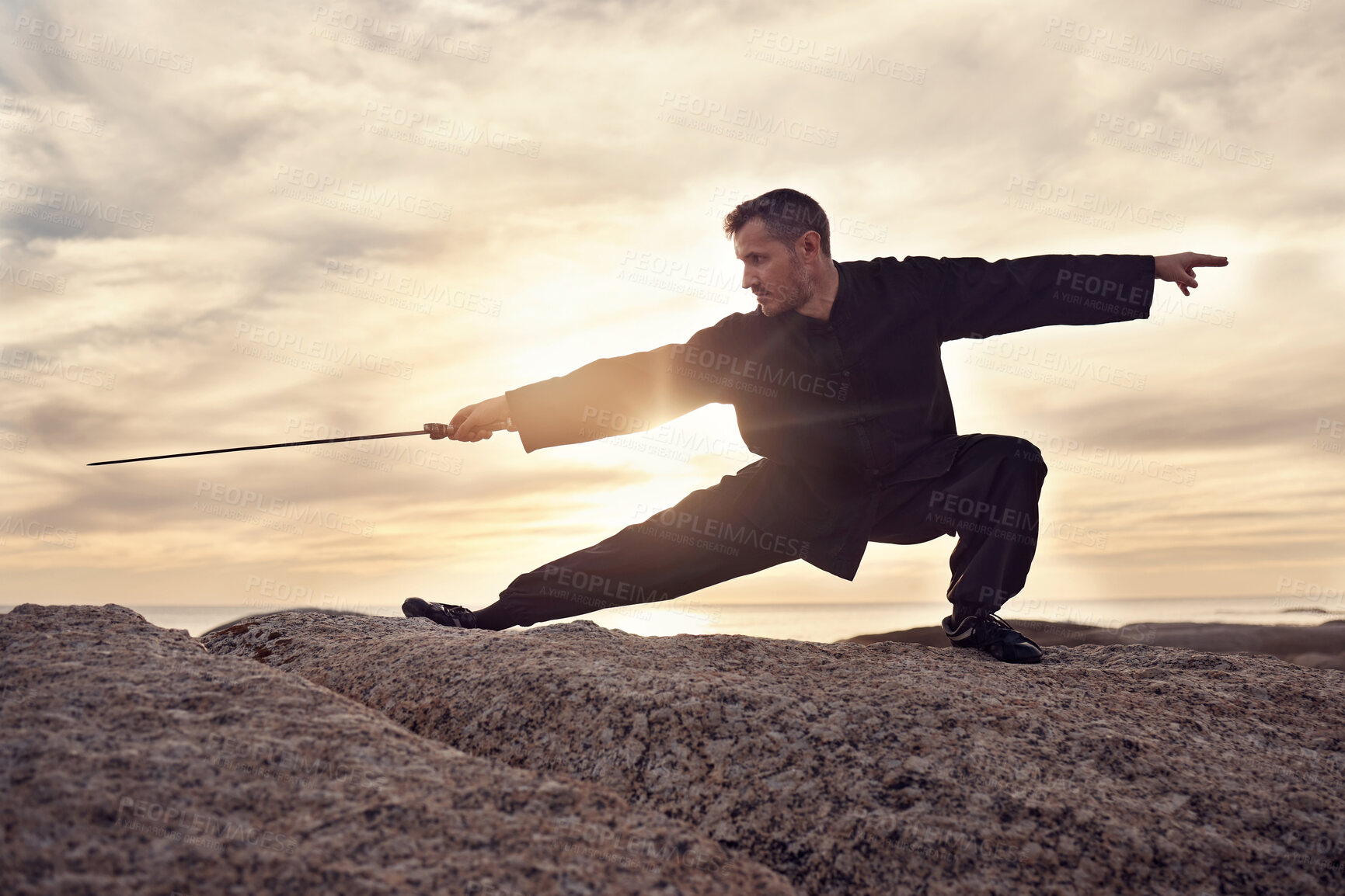 Buy stock photo Martial arts, sword and tai chi, meditation and training at beach, sunset and outdoor in summer in Australia. Man, mindfulness and calm with balance alone in nature, ocean and meditate fo wellness