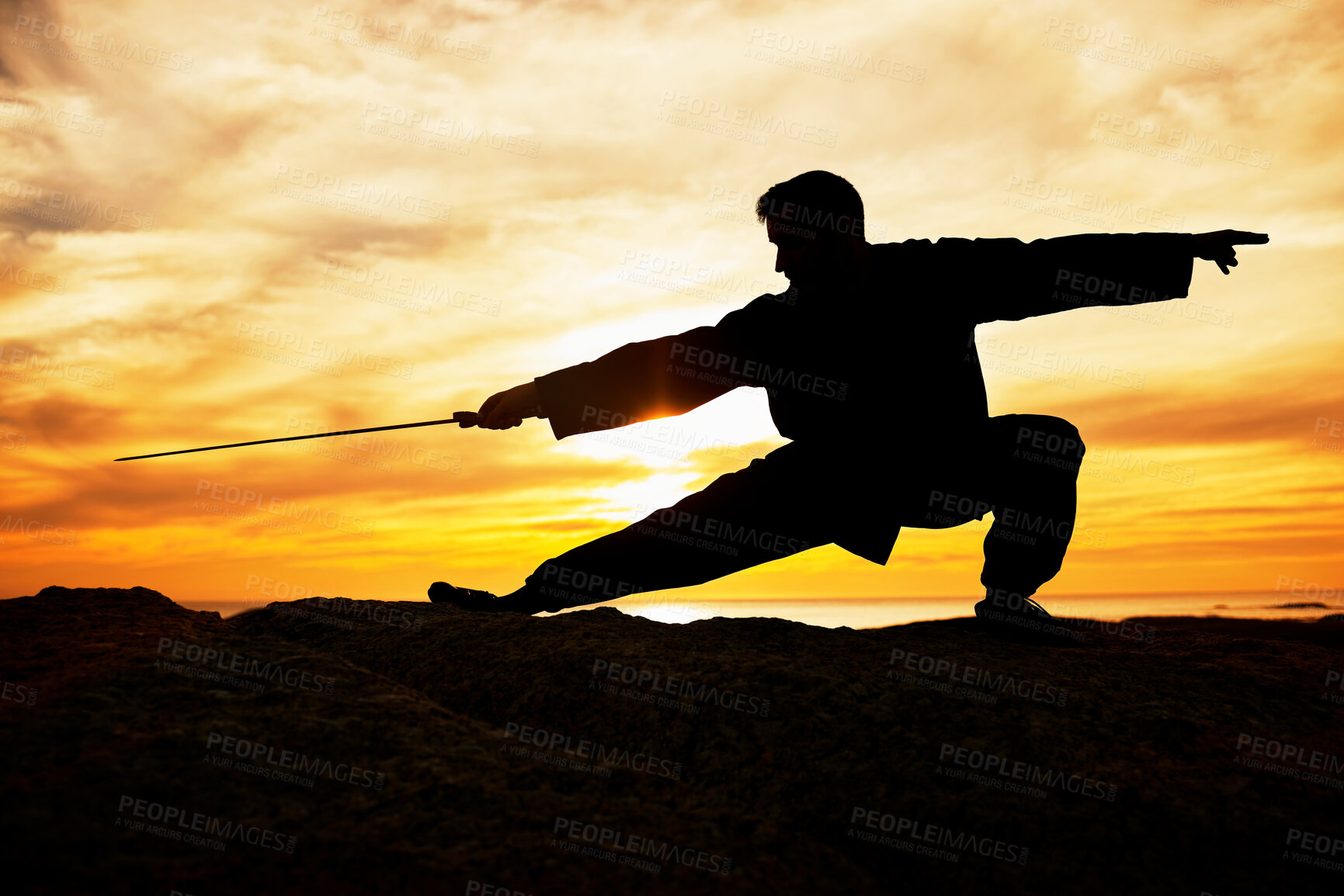 Buy stock photo Sunset, sport and man doing tai chi with a sword on a hill for exercise and fitness workout. Silhouette, training and sports exercising male at sunrise for chi gong practice for health and wellness