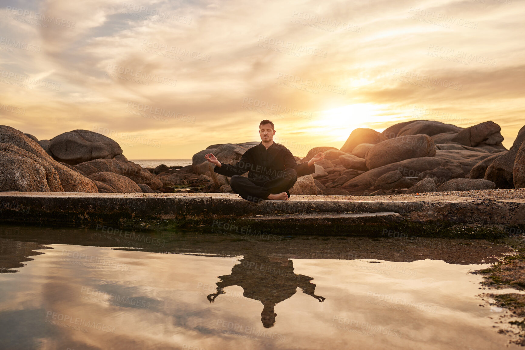 Buy stock photo Sunset, yoga or zen man in meditation by a calm or peaceful lake or beach for a spiritual mindfulness exercise. Nature, wellness or healthy yogi in a lotus pose training his relaxed body to meditate