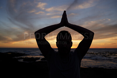 Buy stock photo Sunset, yoga and beach fitness with a flexible man working out for exercise and strength. Ocean, silhouette and male yogi stetching for spiritual and chakra enlightenment while meditating outside 