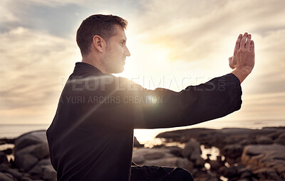 Karate man, martial arts and training to fight at a beach against a cloudy sunset sky for focus, power and energy outdoor. Male fighter ready for sports, fighting and kata exercise for fitness at sea