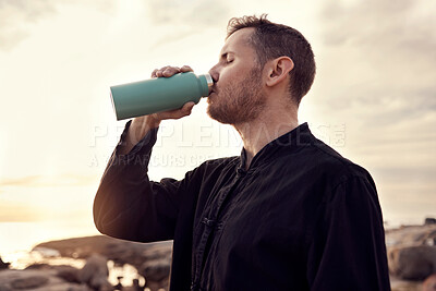 Buy stock photo Drinking water, fitness and nature with a sports man or running taking a break on the beach during exercise. Training, sunset and health with a male athlete staying hydrated during a cardio workout