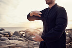 Beach, peace and tai chi, man in nature for balance and peace for mental wellness or control of body and mind. Spiritual health, fitness and meditation, energy and self care on rocks at sea in sunset