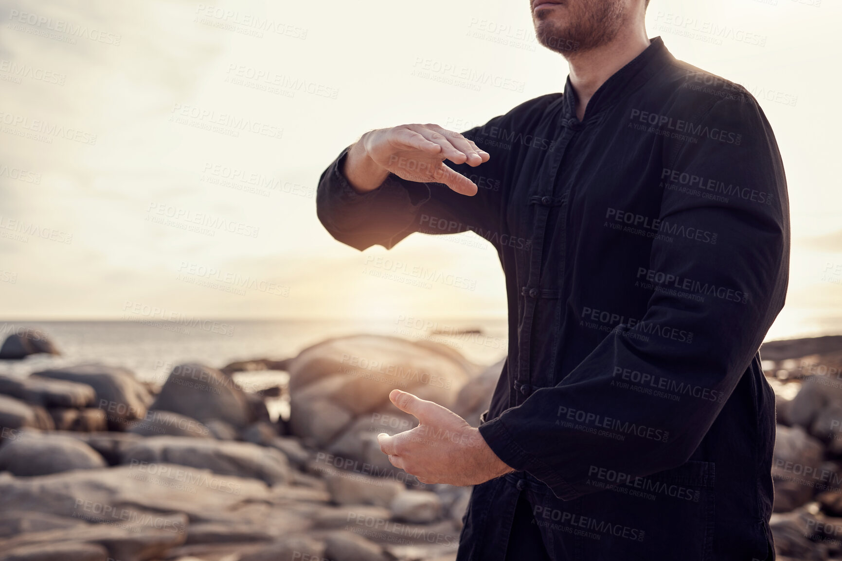 Buy stock photo Beach, peace and tai chi, man in nature for balance and peace for mental wellness or control of body and mind. Spiritual health, fitness and meditation, energy and self care on rocks at sea in sunset