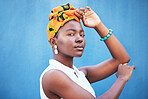 Black woman, beauty and turban for face of african culture, fashion and freedom on a blue background wall for cosmetics, head scarf and makeup mockup. Portrait of female from Nigeria posing for art