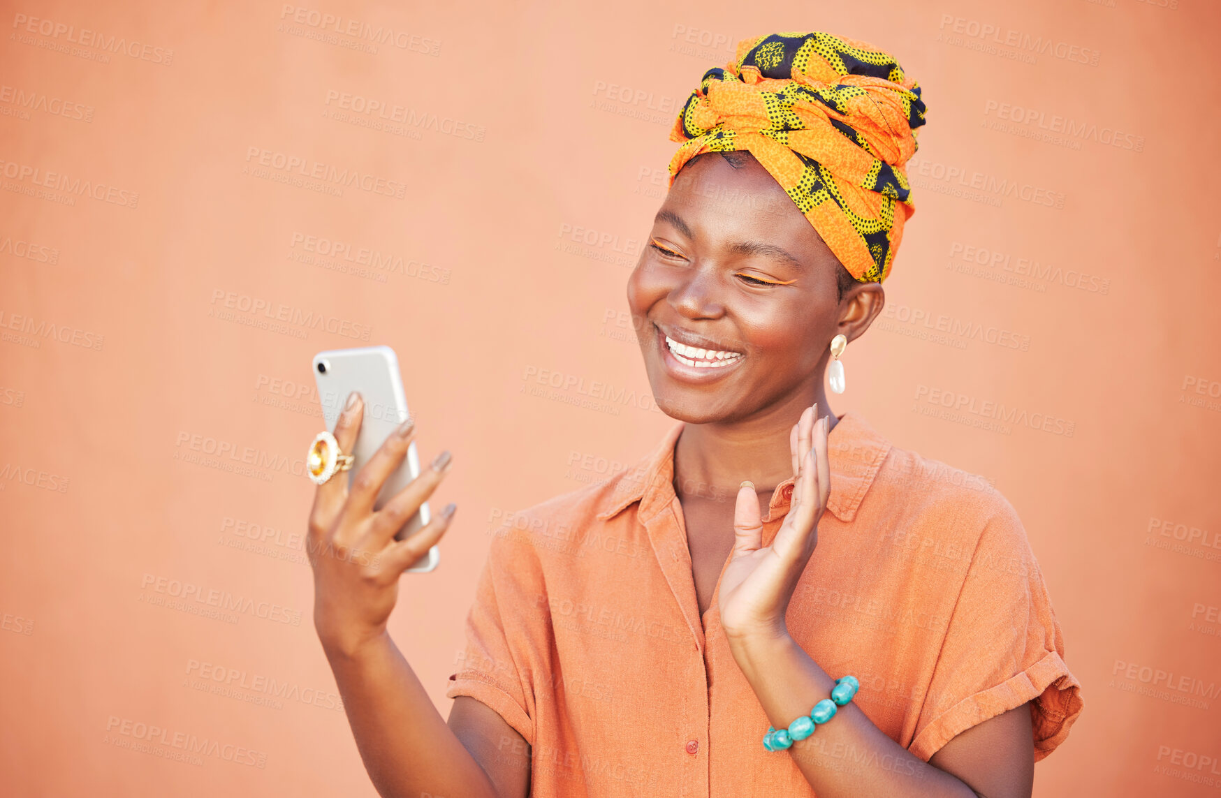 Buy stock photo Black woman, phone and video call, wave and communication outdoor against peach wall outdoor. Gen z girl, fashion and virtual conversation, video conference and happy smile or talking with smartphone