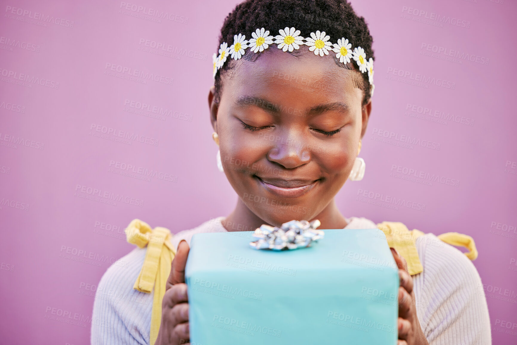 Buy stock photo African woman, box and gift with eyes closed in studio, wall and surprise for birthday, celebration or smile. Black woman, present or happiness for spring flower crown, beauty and lavender background