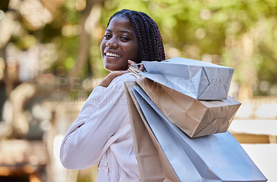 Buy stock photo Black woman, shopping and bags with smile for luxury, self love or self care in the outdoors. Portrait of African American female shopper smiling carrying gifts and enjoying shop or buying spree