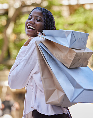 Buy stock photo Black woman, portrait and fashion retail shopping satisfaction with deal, discount and choices. Customer, happiness and smile of girl walking with clothes boutique shopping bags in South Africa.

