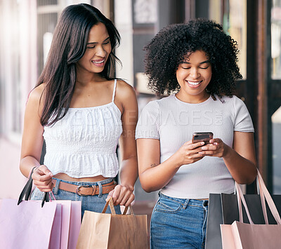 Buy stock photo Women, friends and shopping with phone in city for mobile app connection, technology and internet. Happy customers, shopping bags and search social media for discount stores, fashion sales and market
