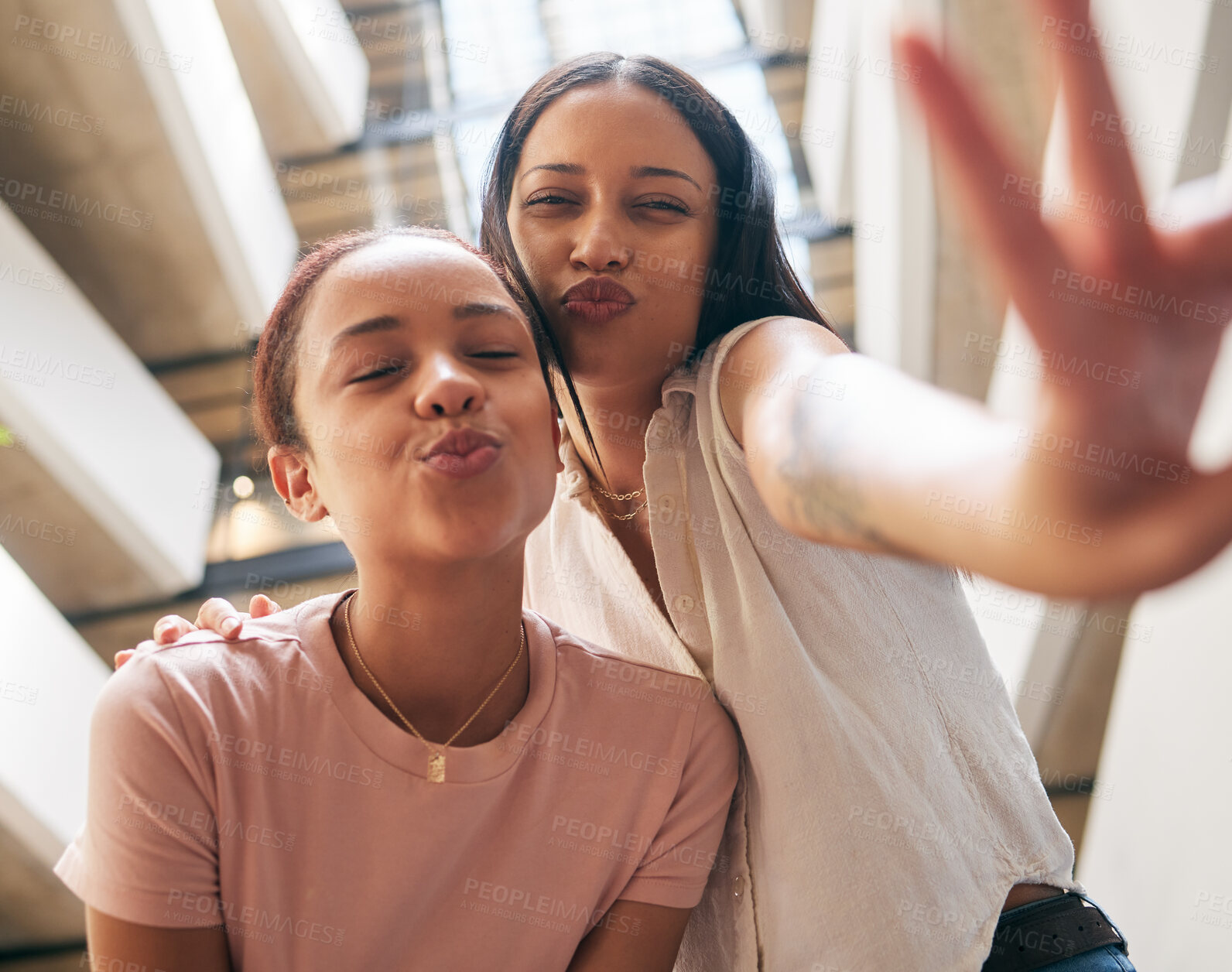 Buy stock photo Peace, kiss and pout with black woman friends in the city together, posing with a hand sign or gesture. Happy, smile and bonding with a young female and her best friend in an urban town from below