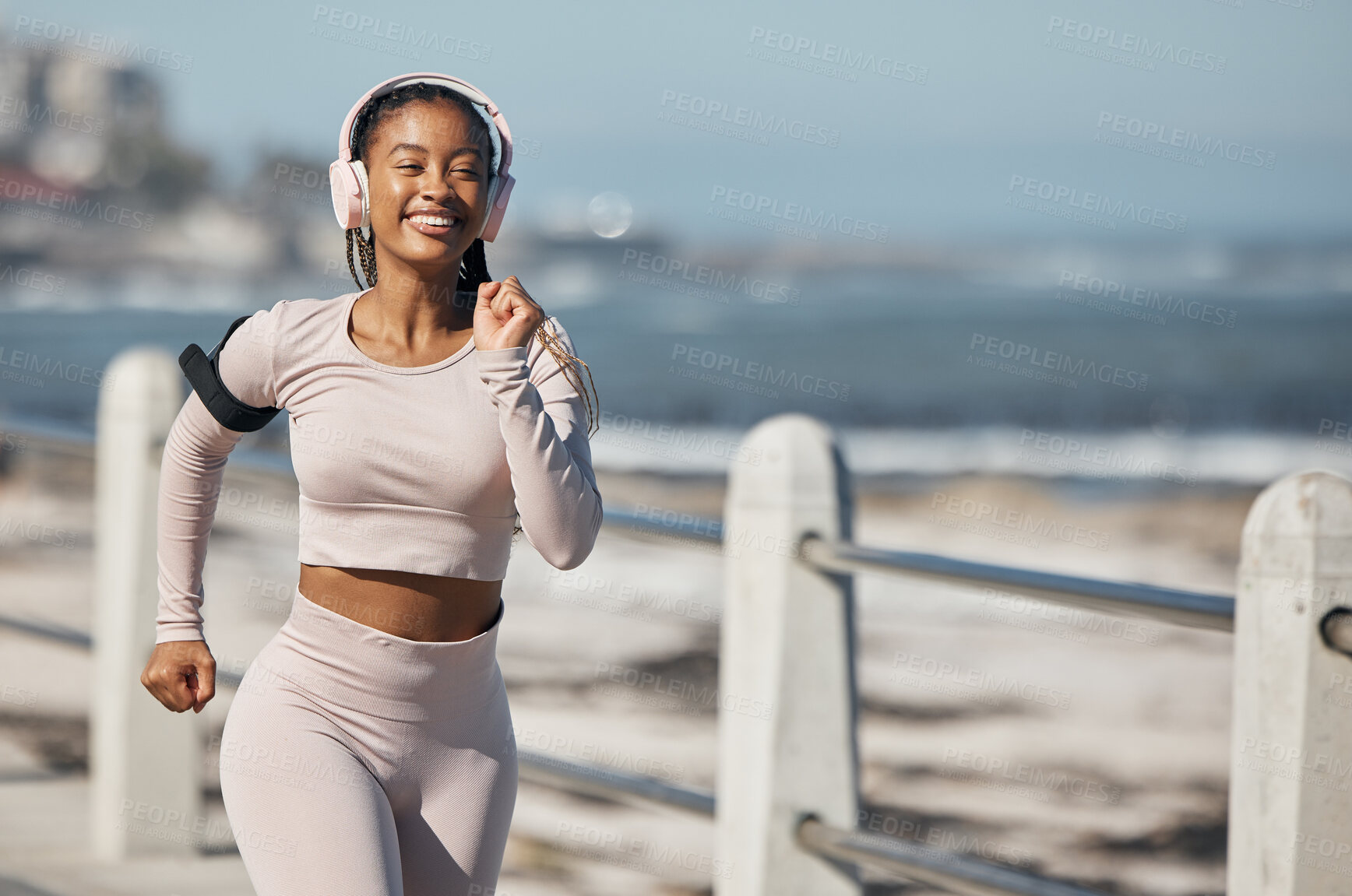 Buy stock photo Beach, fitness and headphones woman running with audio technology for fitness, exercise and speed inspiration in urban city. Black woman, athlete or runner listening to music with fast workout at sea