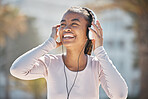 Happy, fitness or black woman with headphones for a podcast, music or radio streaming for motivation in Miami. Nature, smile or healthy girl runner laughing at a funny audio after training exercise