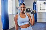 Happy woman, fitness and dumbbell exercise in gym for strong body, wellness and healthy lifestyle goals. Portrait of indian female, sports and happiness with weights for workout, training and power 