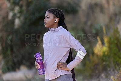 Buy stock photo Fitness, running and black woman with water bottle in nature for wellness, minerals and healthy lifestyle. Exercise, sports and girl with earphones rest, breathe and relax after marathon training 