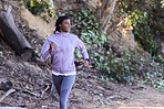 Black woman, running and exercise in forest with happy smile, workout and exercise for health and wellness outdoor. Young female, runner and fitness while training marathon, happy smile and run