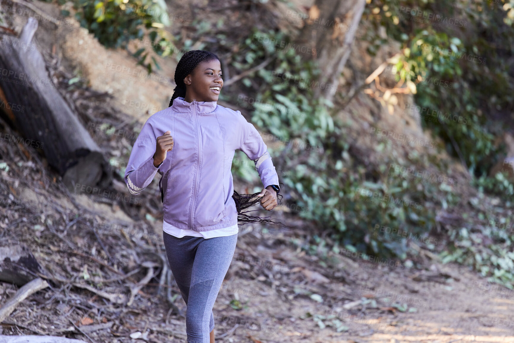 Buy stock photo Black woman, running and exercise in forest with happy smile, workout and exercise for health and wellness outdoor. Young female, runner and fitness while training marathon, happy smile and run