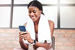 Fitness, phone and black woman relax in gym tracking workout, progress or exercise on app. Sports, mobile tech and happy female with towel and smartphone internet browsing, social media or texting.