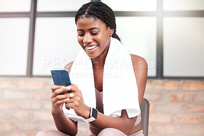 Buy stock photo Fitness, phone and black woman relax in gym tracking workout, progress or exercise on app. Sports, mobile tech and happy female with towel and smartphone internet browsing, social media or texting.