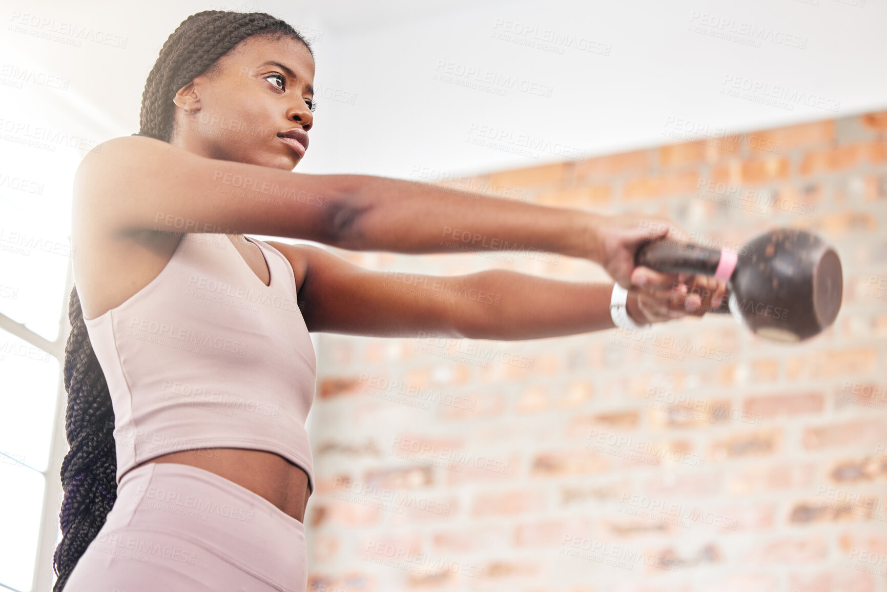 Buy stock photo Fitness, kettlebell weight and black woman doing a workout with strength, motivation and health in a gym. Sports, focus and African female athlete doing a muscle training exercise in a sport center.