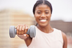 Dumbell, exercise and black woman does fitness workout for muscle growth, body health and strength training on a blurred background rooftop. Sports athlete, healthy and strong African American girl 
