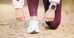 Woman, shoes lace and fitness runner outdoor in nature park for marathon training, cardio run or healthy workout. Athlete person feet, check sneakers and running wellness or exercise in city road