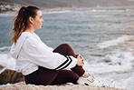 Woman, beach and thinking about future, freedom and life on a rock with zen, peace and calm ocean for mindfulness, meditation and mental health. Female at sea to relax on nature holiday in Sydney