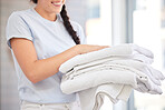Clean towels, laundry and woman doing washing while working for cleaning service, hospitality and housekeeping industry with folded linen. Hands of cleaner in house to change cloth in hotel room