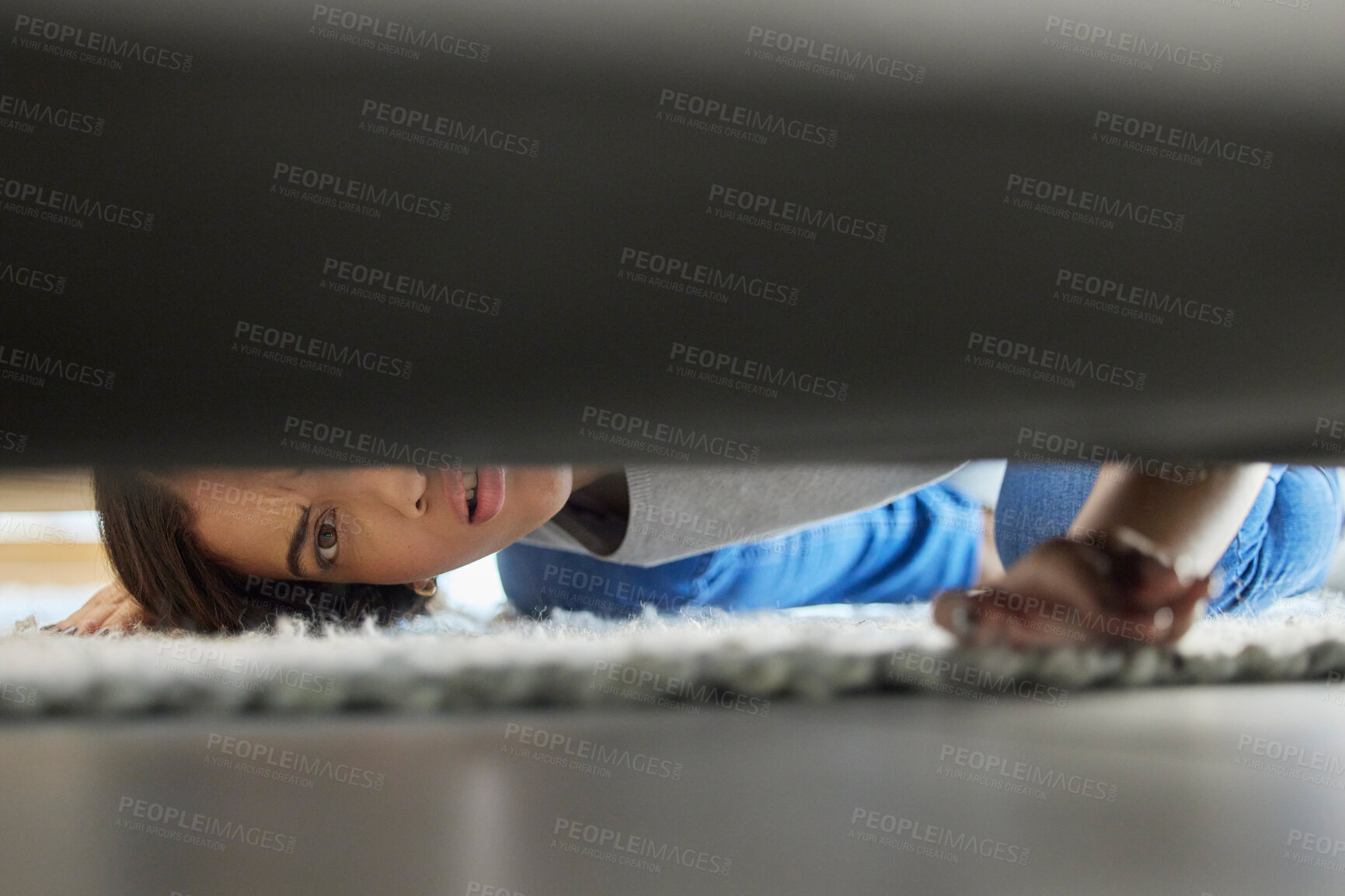 Buy stock photo Woman, confused and couch looking for lost product in her home living room with doubt. Female, floor and checking under sofa for a missing item and searching her apartment or house in the carpet