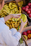 Banana, hands and woman with shopping in marketplace, outdoor and fresh, organic and healthy fruit and vegetables. Grocery shopping, market and customer choice of food, diet and nutrition with fruits