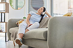 Woman, relax and music headphones on sofa in house, home or hotel living room for mental health, self care or stress management. Zen, student and person listening to radio, podcast or wellness audio