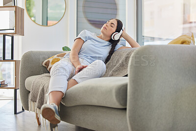 Buy stock photo Woman, relax and music headphones on sofa in house, home or hotel living room for mental health, self care or stress management. Zen, student and person listening to radio, podcast or wellness audio