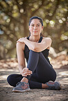 Wellness, fitness and woman sitting in park after exercise, running and workout in the morning. Sports, motivation and portrait of girl on ground in forest to relax, rest and on break from training