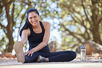 Fitness, runner and portrait of woman stretching on park floor with music, podcast or motivation audio for wellness. Face, runner and girl stretch on ground in nature for training, run and exercise