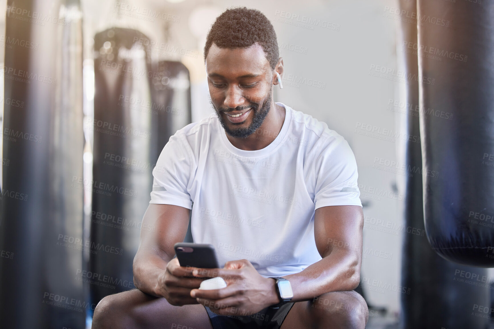 Buy stock photo Fitness, music and phone with black man in gym for training, workout and exercise. Social media, streaming and internet with bodybuilder relax with mobile in sports center for health and performance