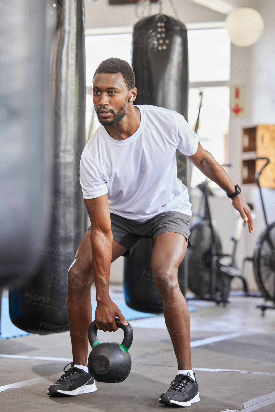 Buy stock photo Exercise, kettlebell and black man doing fitness with a weight with strength, focus and motivation. Sports, exercising and strong African male athlete doing muscle training or workout at a gym