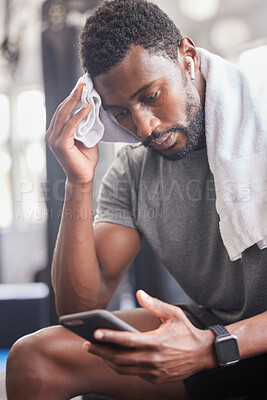 Buy stock photo Gym, workout and tired black man with phone for social media and towel for sweat from cardio. Fitness, rest and exercise fatigue of sweaty guy on smartphone app for body relaxation to recover.