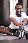 Fitness, stretching and portrait of black man in gym for exercise, workout and training with earphones. Sports, healthy lifestyle and male athlete getting ready, warm up and stretch legs on floor