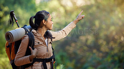 Buy stock photo Hiker, exercise and backpacking with a woman in nature for adventure and carefree freedom. Backpack, hiking and view with a female pointing while in a forest to hike while on a natural environment